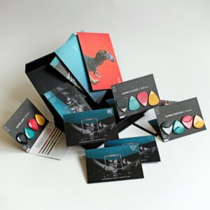 A collection of colorful guitar picks elegantly arranged with modern packaging design, showcasing variety and style.